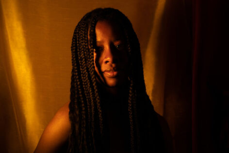 Maria J Hackett poses in a self portrait in her choice of protective styling as a woman of color, continuously growing and learning to be proud of her unique being as a woman, mother and individual.