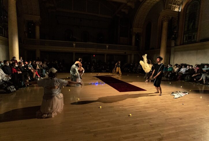loveconductors performing at Movement Research at the Judson Church. Dancers are in motion executing different actions. One of them is squatting with arms to the side, another is in a gentle pelvic tilt body wrapped in fabric and fluorescent lights, at distance a dancer is walking with a big rope between the hands, another dancer swings a flowy fabric through the hair. Photo by Rachel Keane.