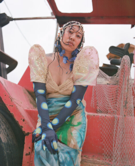 Kat Sotelo is a first-generation Filipino American performance artist, choreographer, and set designer whose practice blends movement, satire, and constructed environments. She explores the body as a site of commerce, often using her experience in