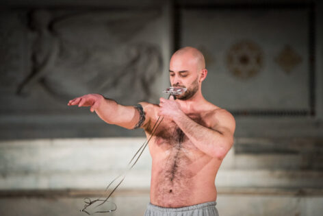 Christopher holds a cassette tape to his mouth as he pulls the tape out with his hands. Photo by Cherylynn Tsushima