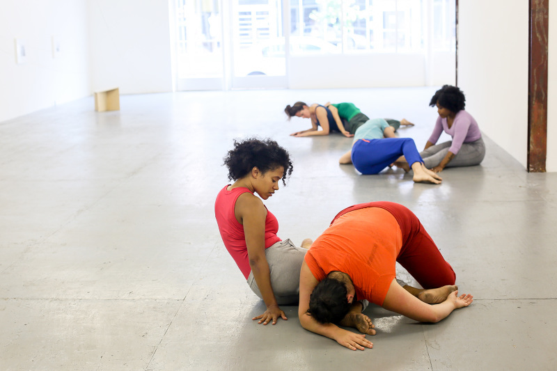Dancers in colorful clothing moving about in an open space. Leslie Cuyjet, Fossil, 2017. A Collection of Slow Events, The Luminary Gallery, St. Louis. Photo by Brea McAnally
