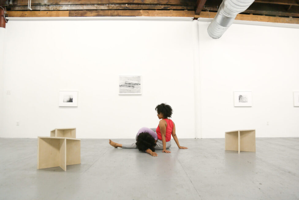 Two dancers in a large art gallery.