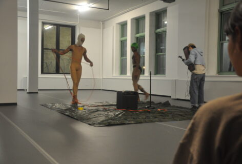 From the MR Archives: Open Performance. Three performers set up on a square tarp, they have cords and a large amp in the center of them. Artist Unknown. Photo by Mary Anne Bodnar.