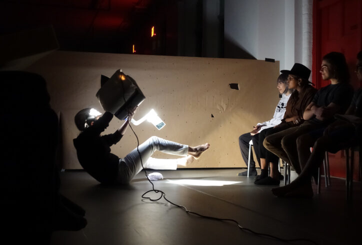 From the MR Archives. 2019, Open Performance: A performer sits on the floor with a light while they hover their legs and an audience observes. Photo by Harry Shunyao Zhang.