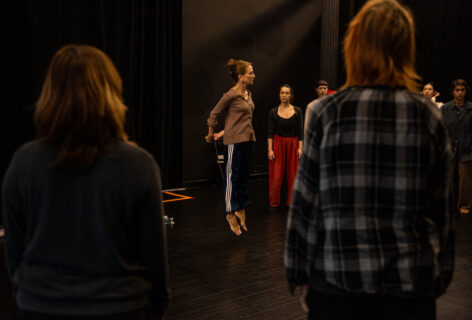 From the MR Archives; 2024.07.12. Summer MELT. Shelley Senter. Photo by Rachel Keane. Shelley mid air with her hands behind her back, students watch her in action.