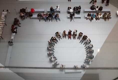 2019, an aerial shot of a group of dancers in sitting a circle for a workshop with Jimena Paz for Movement Research at MoMa. Photo by Andrew Kim
