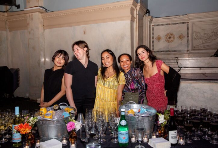A group of interns smile and wave at the camera. Photo from the MR Intern party.