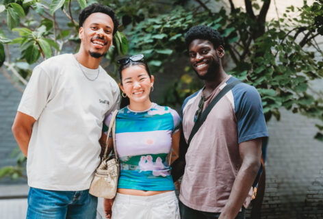 2025 AoCC Cookout attendees smile at the camera in front of a tree. Aisha Bee Photography.