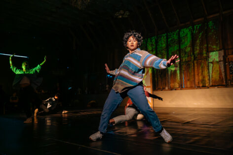 A Filipino woman with short wavy hair in motion with arms and legs wide apart.