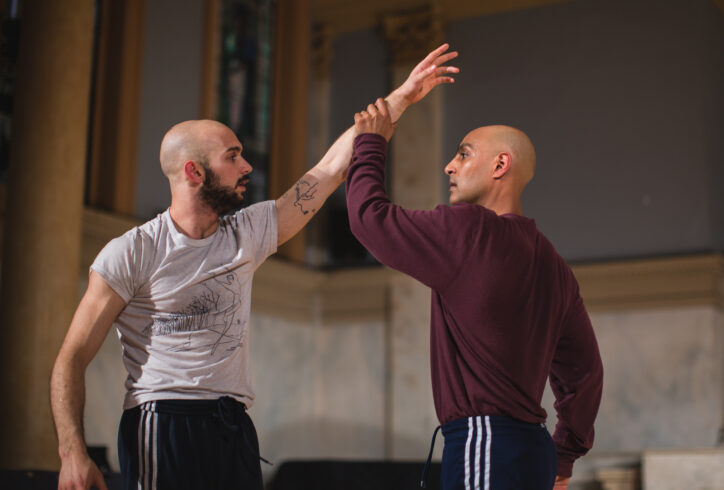 Paul, on the right in the burgundy shirt, holds the arm of Jack Blackmon, on the left, while they look directly at each other. Photo by David Gonsier.