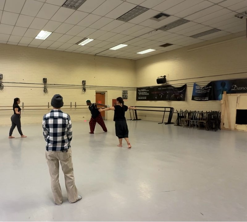 Dancers rehearsing in a studio. 