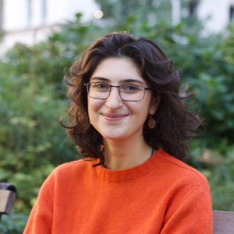 Amira is wearing an orange sweater and glasses. Photo courtesy of artist.